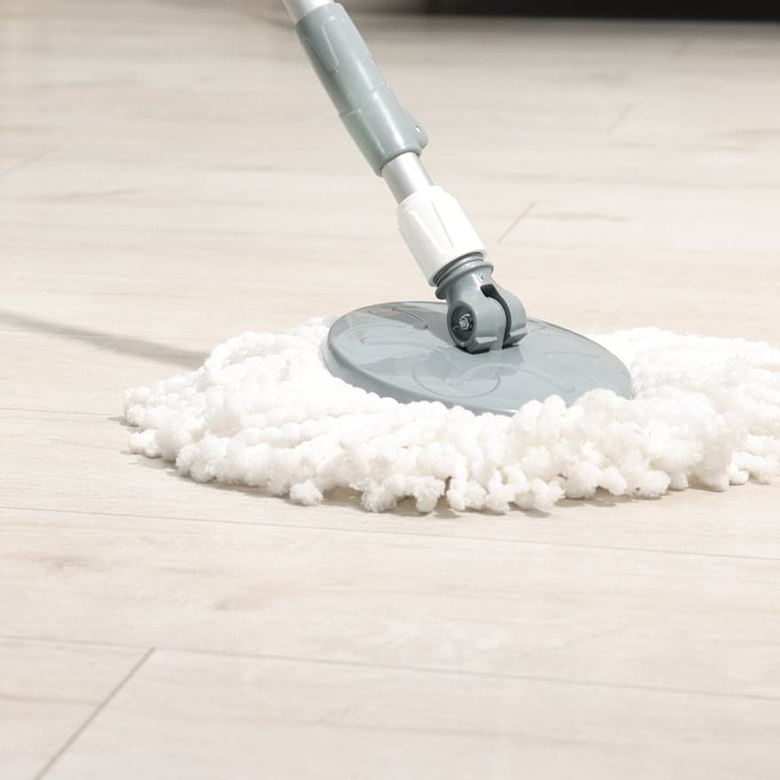 A spin mop being worked across a hard floor